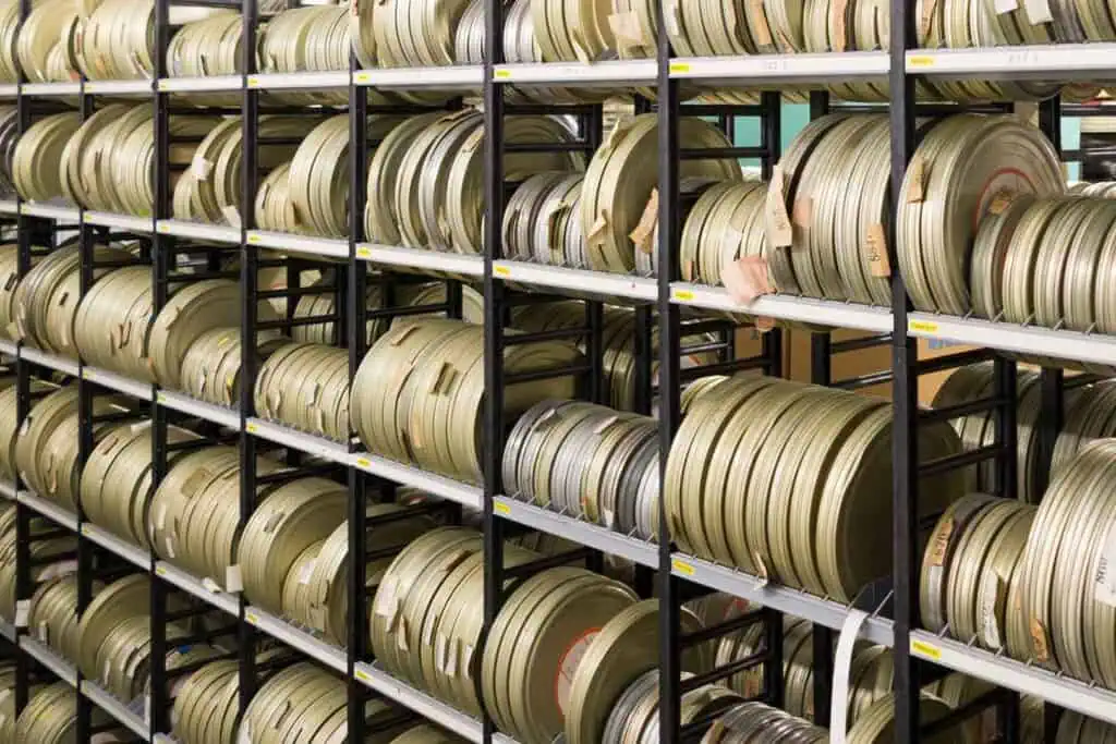 Ein großes Regal voller Filmrollen in Metallbehältern, die in Reihen gestapelt sind.