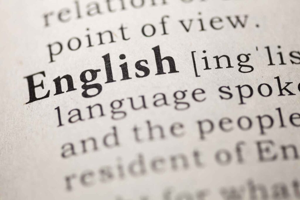Eine Nahaufnahme des Wortes "English" in einem Wörterbuch, mit seiner phonetischen Umschrift und einem Teil der Definition, die besagt, dass es eine Sprache ist.